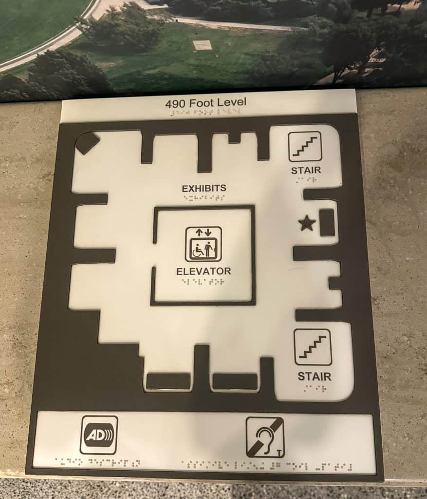 A tactile and braille floor map of the 490-foot observation level of the Washington Monument, showing the layout with labeled sections for exhibits, elevators, stairs, and accessibility features including audio description and hearing assistance.